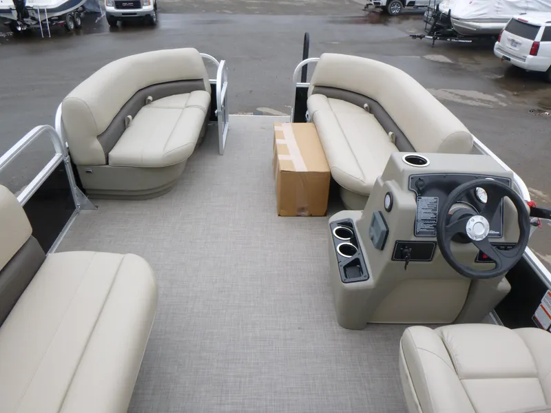 Slide: The Image of 2025 Sun Tracker Party Barge 16 DLX interior with beige seating and steering console. - 9