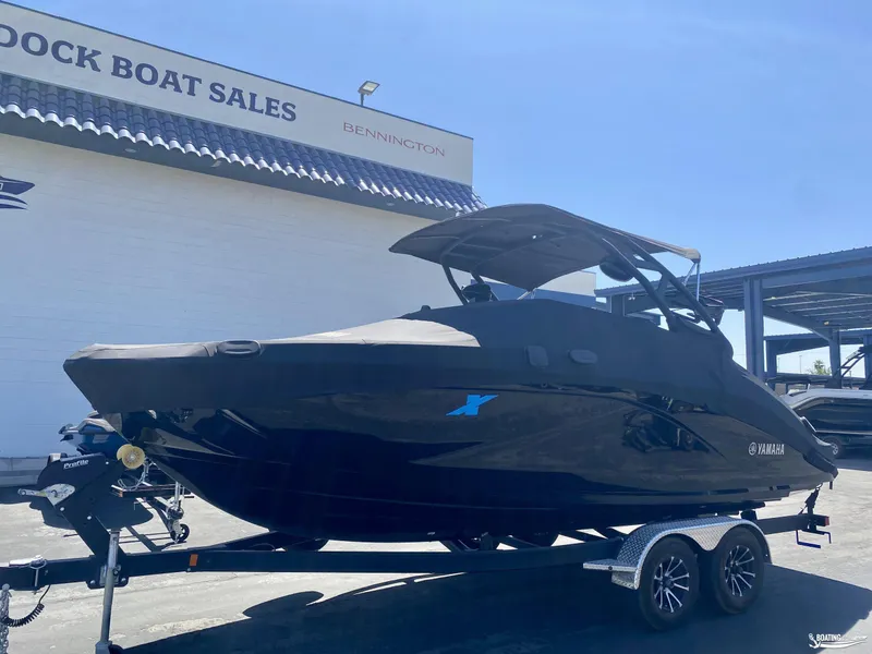 Slide: The Image of 2023 Yamaha Boats 222XE in black, displayed at a boat sales location. - 4