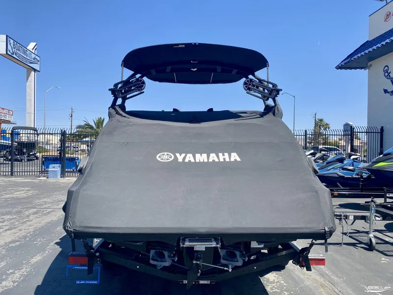Slide: The Image of 2023 Yamaha Boats 222XE covered, parked outdoors at a dealership. - 5