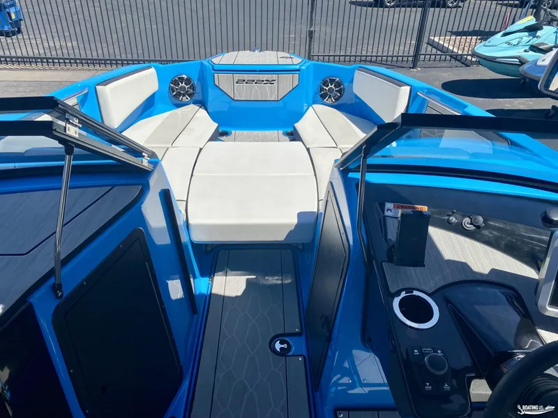 Slide: The Image of 2023 Yamaha Boats 222XE interior with blue and white seating, modern dashboard, and cup holder. - 8