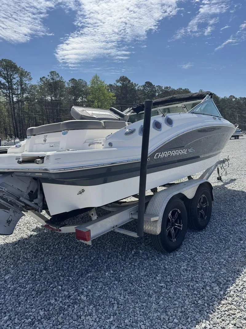 Slide: The Image of 2014 Chaparral 206 SSi boat on trailer, parked on gravel, under clear sky. - 7