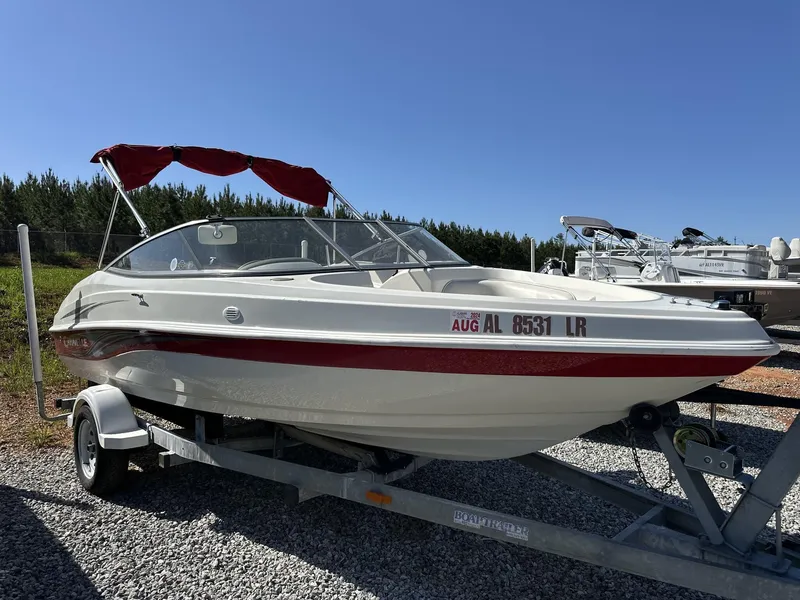 Slide: The Image of 2007 Caravelle 182 186 Model boat on trailer, red canopy, parked outdoors. - 2