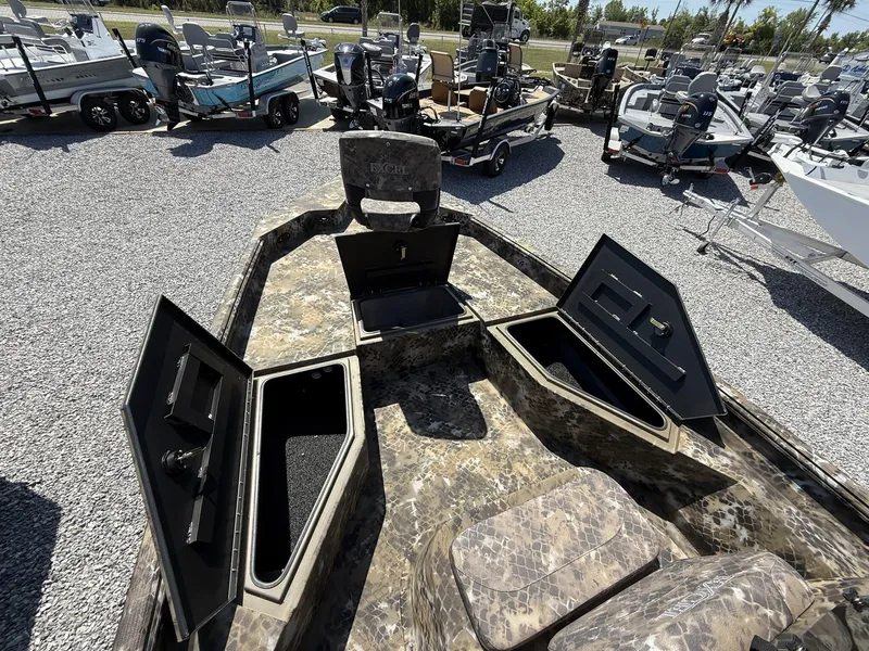 Slide: The Image of 2025 Excel Bay Pro 203 Elite boat with open storage compartments, displayed outdoors. - 5