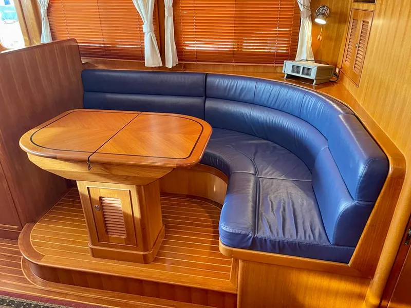 Slide: The Image of Luxurious Selene Archer 36 yacht interior with blue leather seating and wooden table, 2006 model. - 27