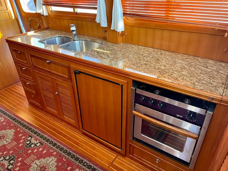 Slide: The Image of Luxurious 2006 Selene Archer 36 yacht kitchen with granite countertops and wooden cabinetry. - 29