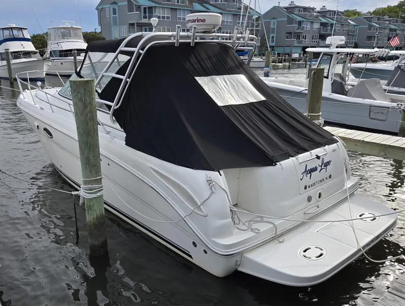 The Image of 2005 Sea Ray 290 Amberjack docked at marina, covered with black tarp. - 0