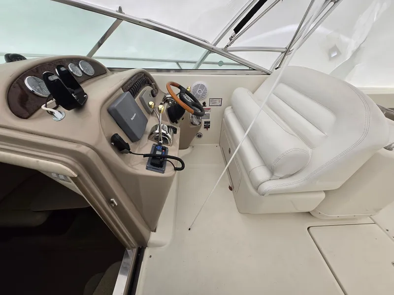 Slide: The Image of 2005 Sea Ray 290 Amberjack cockpit with steering wheel, gauges, and white seating. - 11