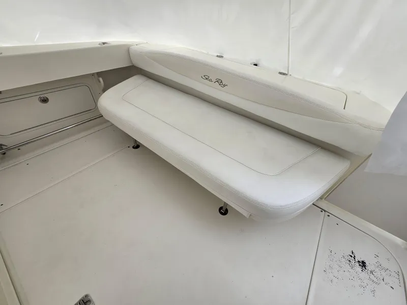 Slide: The Image of 2005 Sea Ray 290 Amberjack boat interior with white seating and storage compartment. - 17