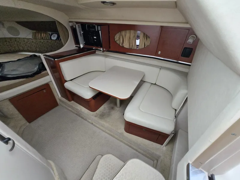 Slide: The Image of 2005 Sea Ray 290 Amberjack cabin interior with dining area and seating. - 28