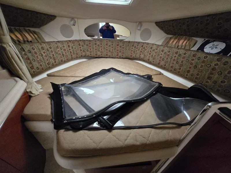 Slide: The Image of 2005 Sea Ray 290 Amberjack cabin interior with bed and window cover. - 30