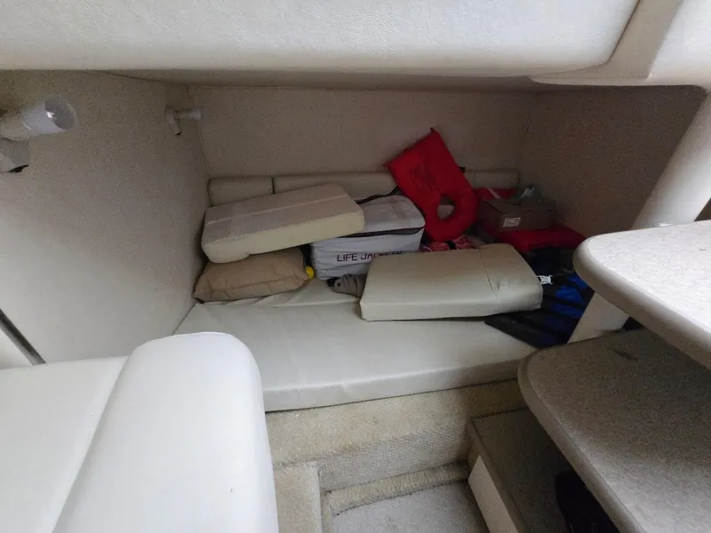 Slide: The Image of 2005 Sea Ray 290 Amberjack cabin interior with life jackets and cushions. - 32