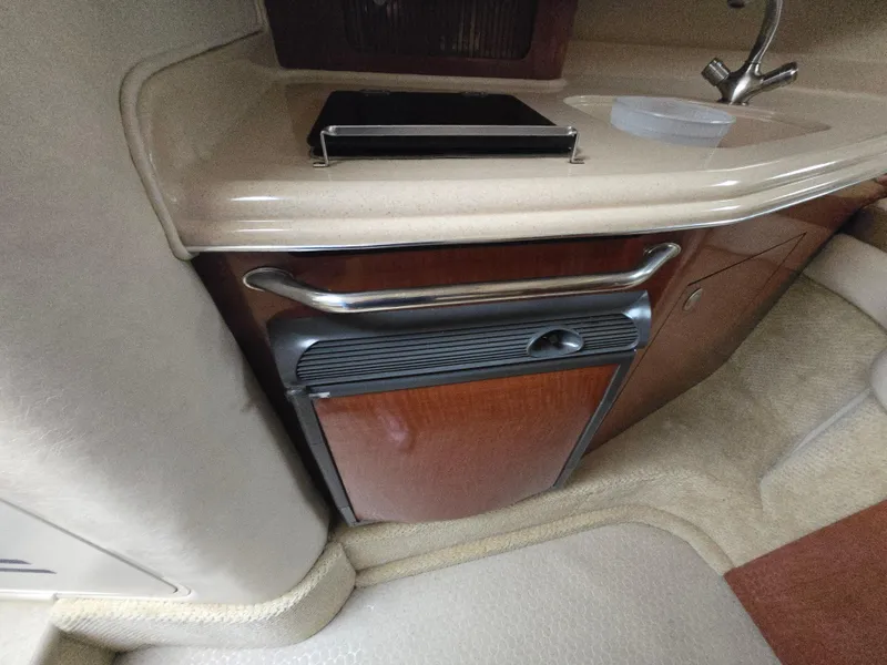 Slide: The Image of Interior of 2005 Sea Ray 290 Amberjack, featuring a compact kitchenette with sink and storage. - 34