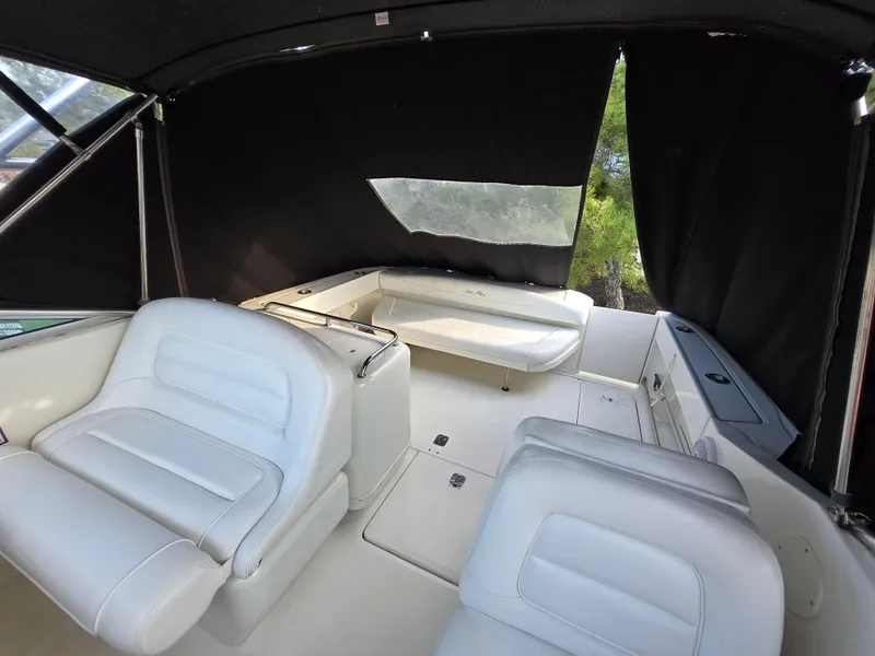 Slide: The Image of 2005 Sea Ray 290 Amberjack interior with white seating and covered deck area. - 4