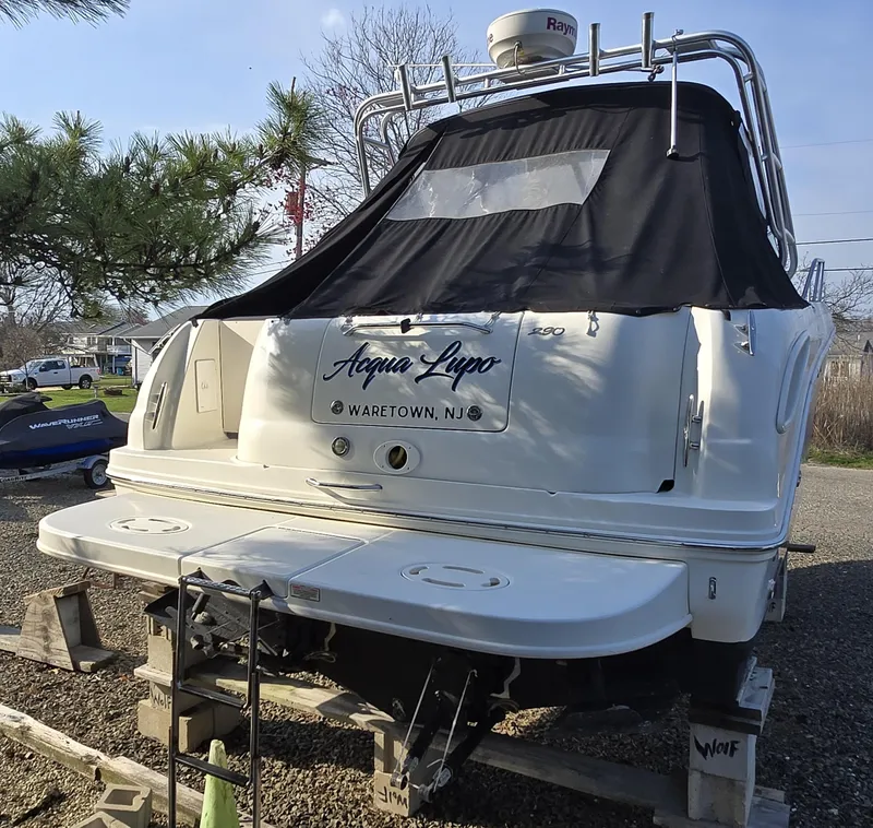 Slide: The Image of 2005 Sea Ray 290 Amberjack boat on blocks, rear view with black cover. - 40