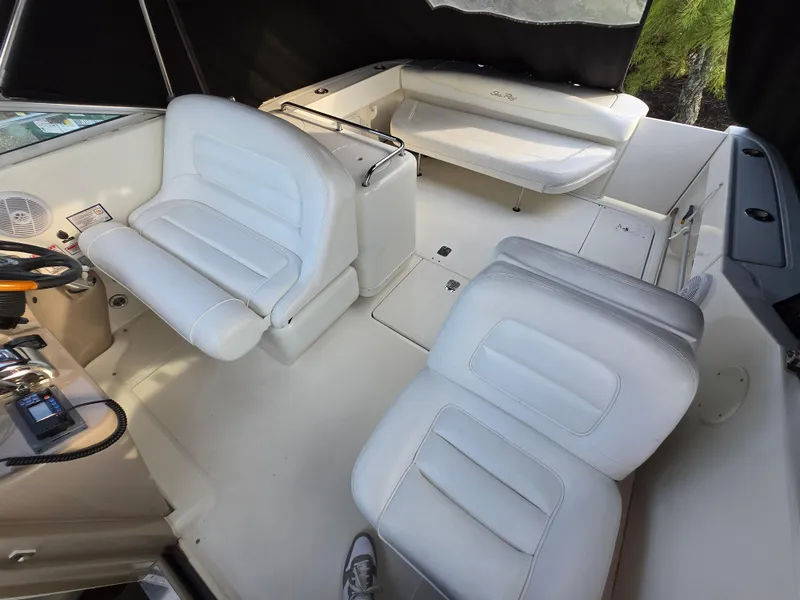 Slide: The Image of 2005 Sea Ray 290 Amberjack boat interior with white seating and helm controls. - 45