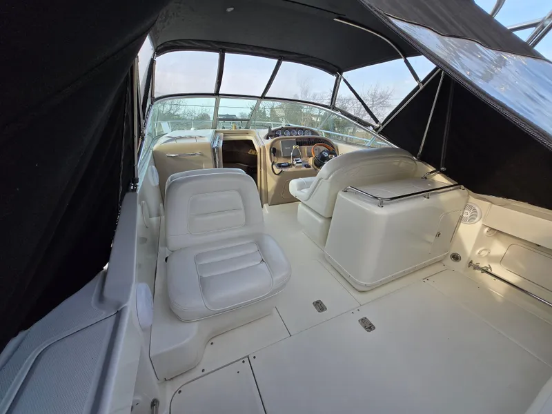 Slide: The Image of 2005 Sea Ray 290 Amberjack boat interior with white seating and covered cockpit. - 5