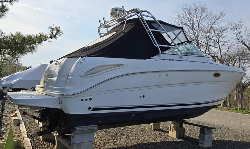 Slide: The Image of 2005 Sea Ray 290 Amberjack boat on blocks, side view with black cover. - 7