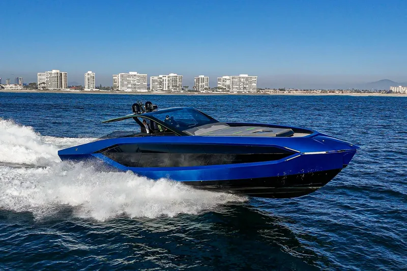 Slide: The Image of 2023 Tecnomar Lamborghini 63 yacht cruising on open water, with city skyline in background. - 11