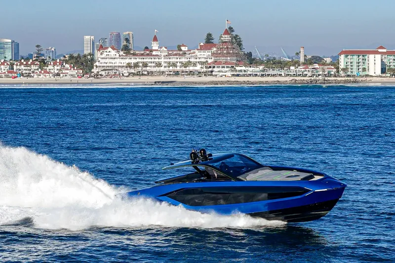 Slide: The Image of 2023 Tecnomar Lamborghini 63 yacht cruising near a coastal cityscape. - 3