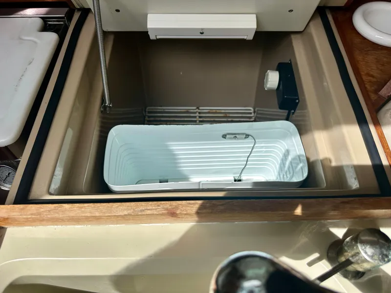 Slide: The Image of 1988 C&C MKII boat interior with built-in cooler and storage compartment. - 10