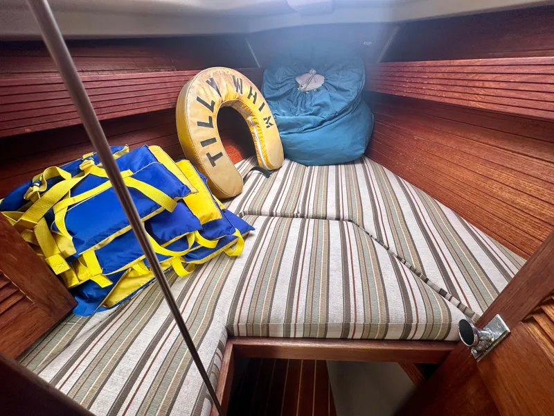 Slide: The Image of Cozy cabin interior of 1988 C&C MKII sailboat with striped cushions and life jackets. - 24