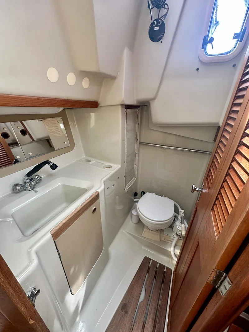 Slide: The Image of 1988 C&C MKII yacht bathroom with sink, toilet, and wooden accents. - 26