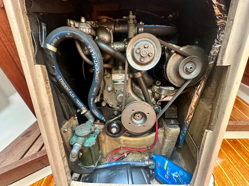 Slide: The Image of Engine compartment of a 1988 C&C MKII sailboat, featuring belts and hoses. - 28