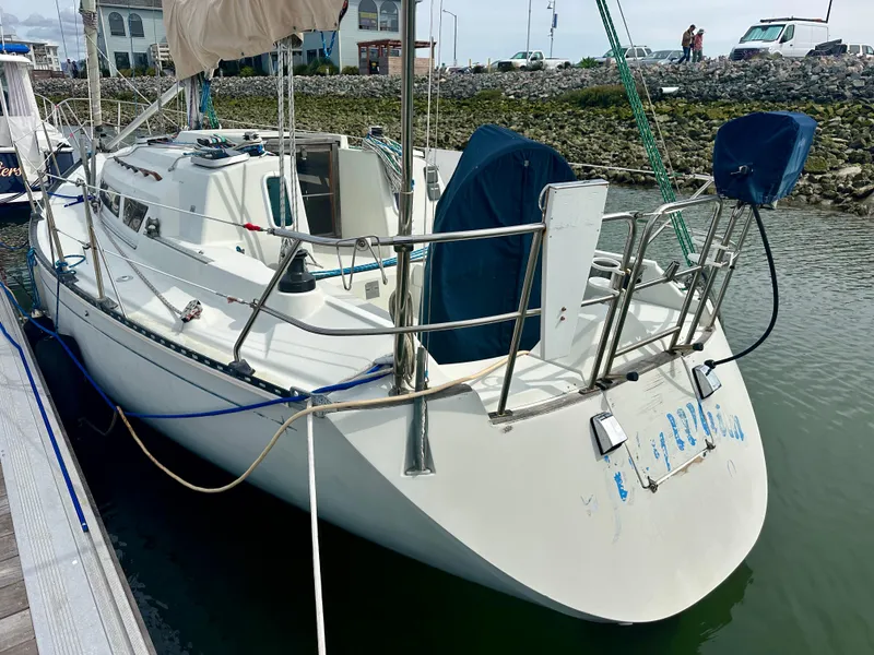 Slide: The Image of 1988 C&C MKII sailboat docked at marina, featuring white hull and blue accents. - 4