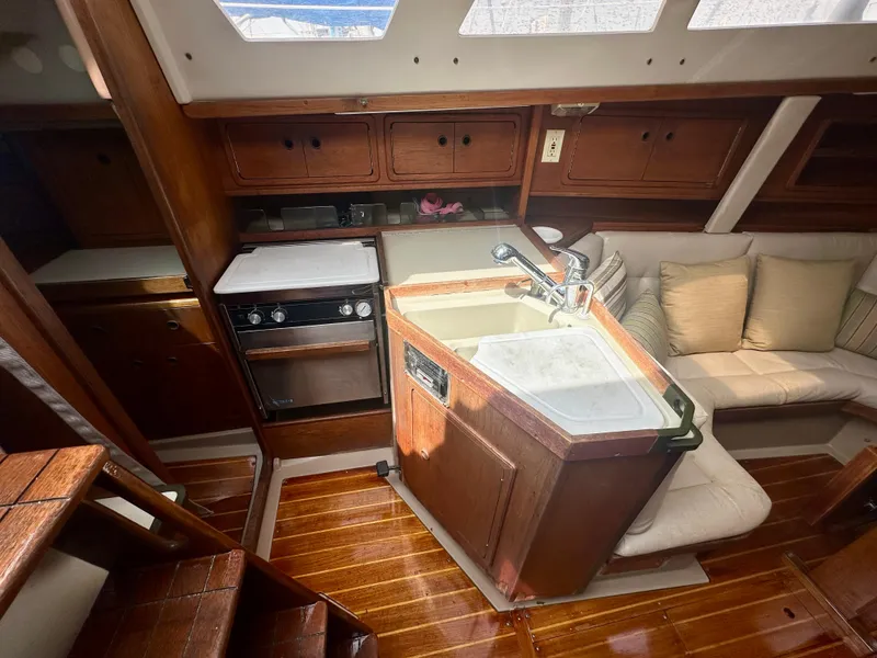 Slide: The Image of Interior of a 1988 C&C MKII sailboat with wooden cabinetry and cozy seating. - 8