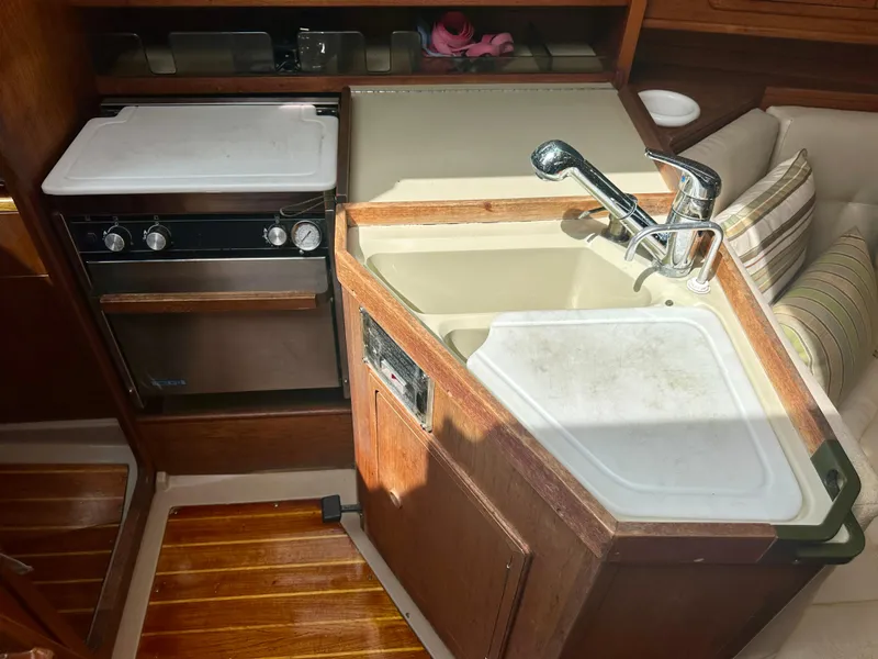 Slide: The Image of 1988 C&C MKII yacht kitchen with sink, stove, and wooden cabinetry. - 9