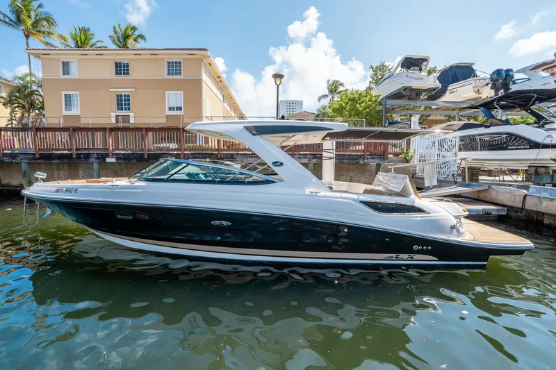 Slide: The Image of 2015 Sea Ray 350 SLX boat docked in a sunny marina setting. - 1