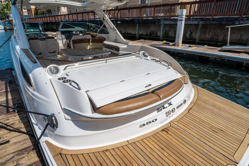 Slide: The Image of 2015 Sea Ray 350 SLX luxury boat docked, featuring spacious seating and sleek design. - 10