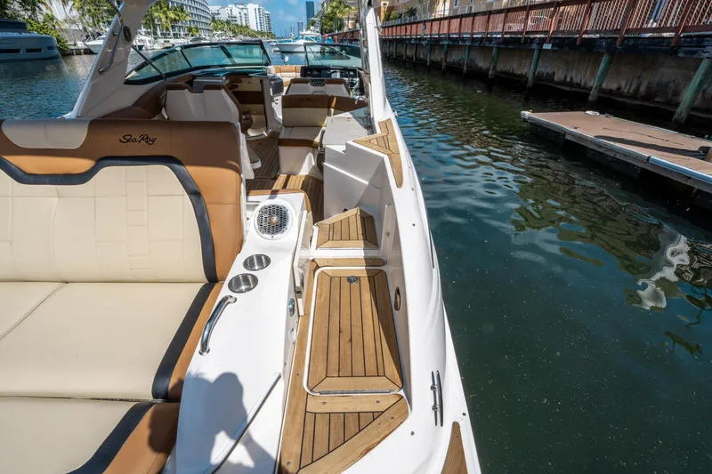 Slide: The Image of 2015 Sea Ray 350 SLX boat with luxurious seating and wooden deck by a dock. - 12