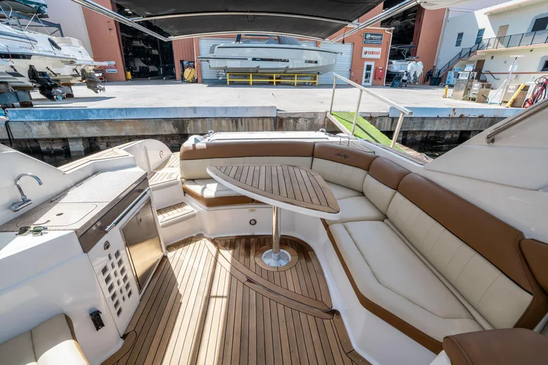 Slide: The Image of 2015 Sea Ray 350 SLX boat interior with teak flooring and cushioned seating. - 15
