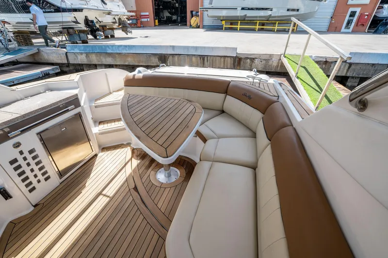 Slide: The Image of 2015 Sea Ray 350 SLX boat interior with elegant seating and wooden table. - 17