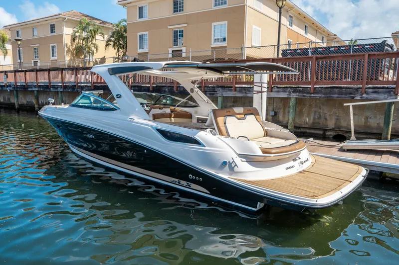 Slide: The Image of 2015 Sea Ray 350 SLX boat docked in a sunny marina setting. - 2