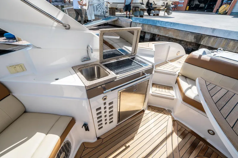 Slide: The Image of 2015 Sea Ray 350 SLX boat interior with kitchenette and seating area. - 21