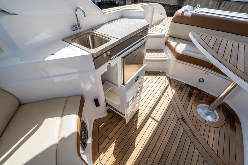 Slide: The Image of Luxurious 2015 Sea Ray 350 SLX boat interior with teak flooring and kitchenette. - 24