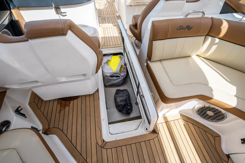 Slide: The Image of 2015 Sea Ray 350 SLX boat interior with open storage compartment and cushioned seating. - 36