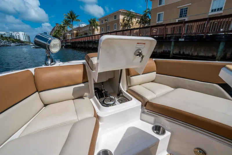 Slide: The Image of 2015 Sea Ray 350 SLX boat interior with tan and white seating, open storage compartment. - 41