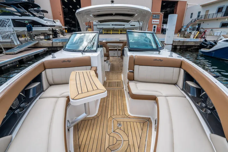 Slide: The Image of 2015 Sea Ray 350 SLX boat interior with luxurious seating and wooden flooring at a marina. - 43
