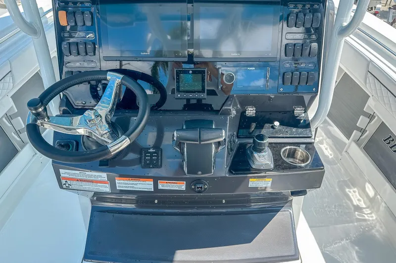 Slide: The Image of 2023 Blackfin 302CC boat helm with steering wheel and navigation controls. - 11