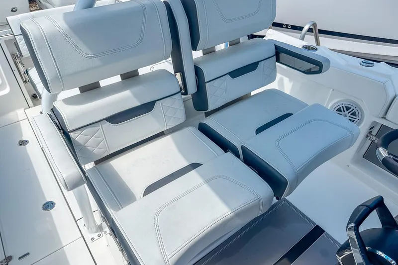 Slide: The Image of 2023 Blackfin 302CC boat seating with white cushioned seats and armrests. - 14