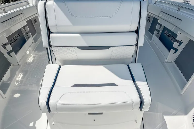 Slide: The Image of 2023 Blackfin 302CC boat interior with white cushioned seating and sleek design. - 18