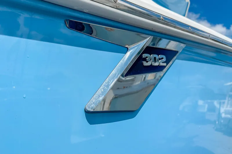 Slide: The Image of Close-up of 2023 Blackfin 302CC boat emblem on blue hull. - 7