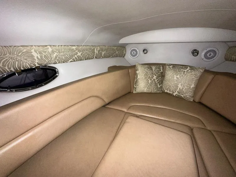 Slide: The Image of 2015 Crownline 236 SC cabin interior with beige seating and floral-patterned cushions. - 10