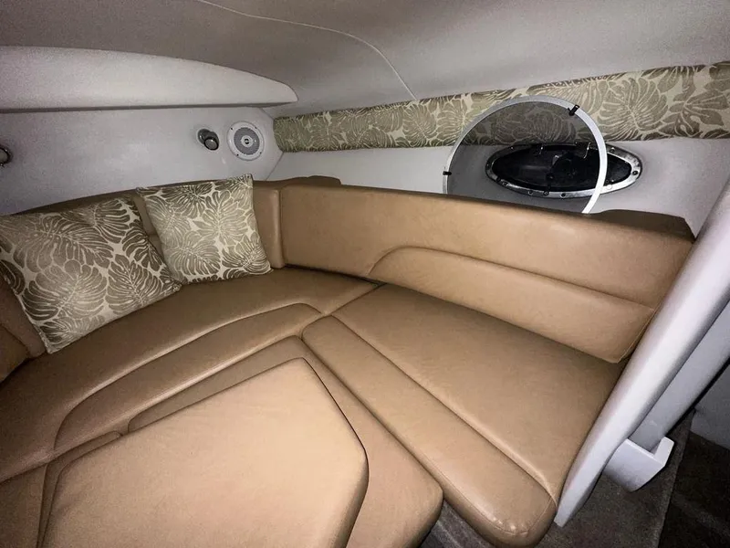 Slide: The Image of 2015 Crownline 236 SC cabin interior with beige seating and floral cushions. - 13