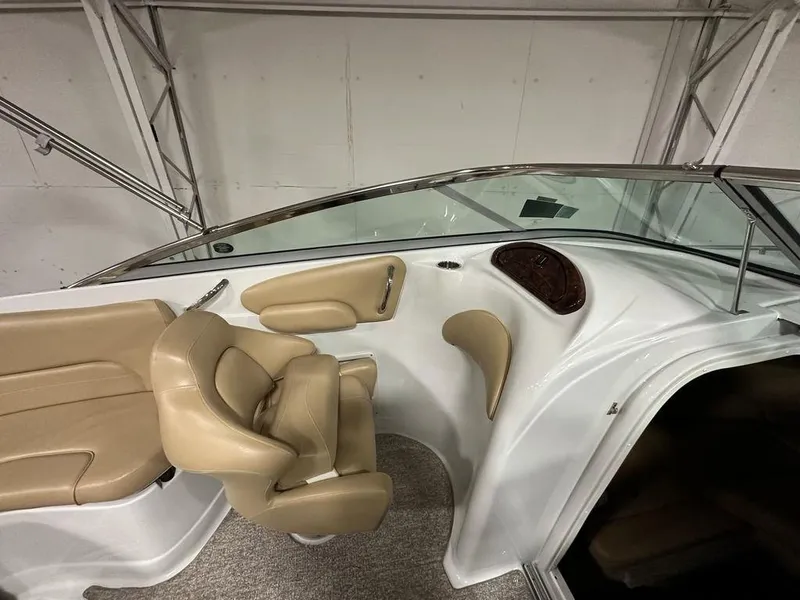 Slide: The Image of 2015 Crownline 236 SC boat interior with beige seating and sleek dashboard design. - 15
