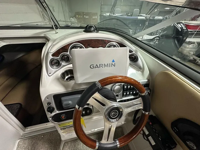 Slide: The Image of 2015 Crownline 236 SC boat dashboard with Garmin navigation system and wooden steering wheel. - 17