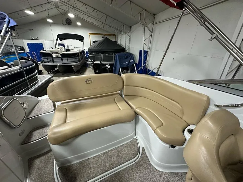 Slide: The Image of Interior of a 2015 Crownline 236 SC boat with beige seating in a showroom. - 20